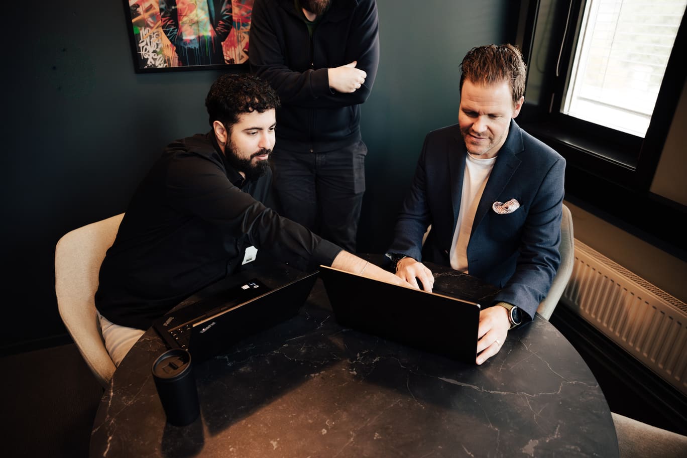 Kontormiljø med ansatte foran datamaskiner – illustrasjonsbilde til tema om sosial manipulering.